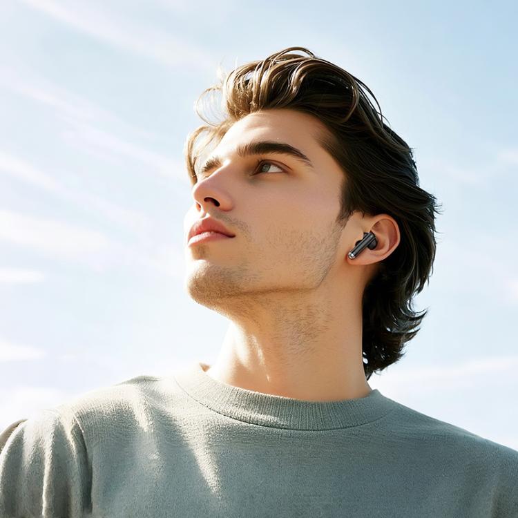 Man wearing wireless earbuds with a clear blue sky background